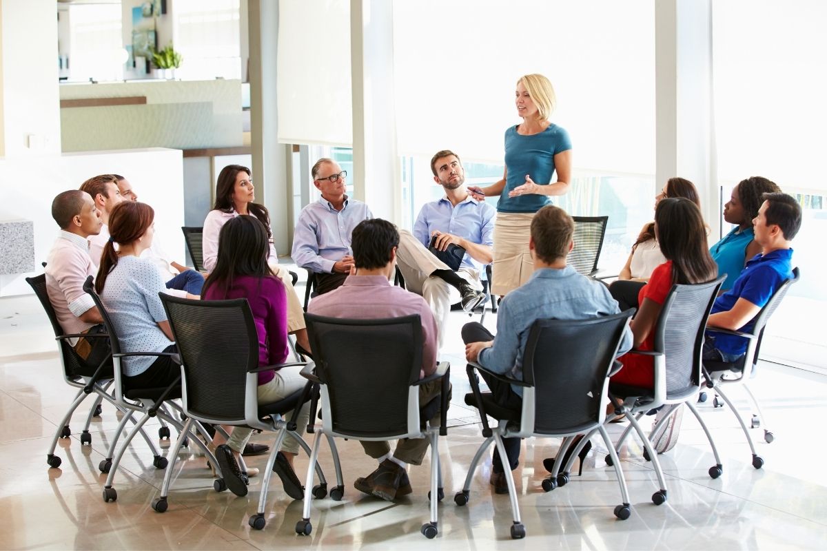reunião de funcionários sentados em círculo e compartilhando suas ideias.